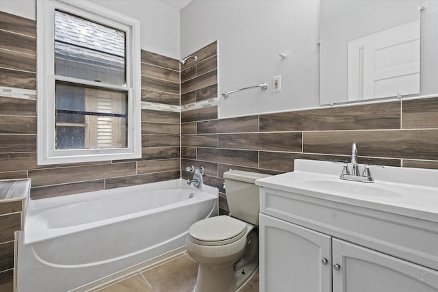 bathroom featuring tile patterned floors, toilet, a bathing tub, tile walls, and vanity