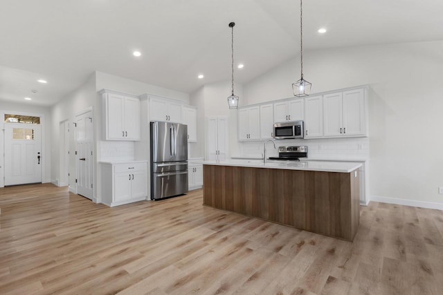 kitchen with light wood-style flooring, appliances with stainless steel finishes, white cabinets, and light countertops