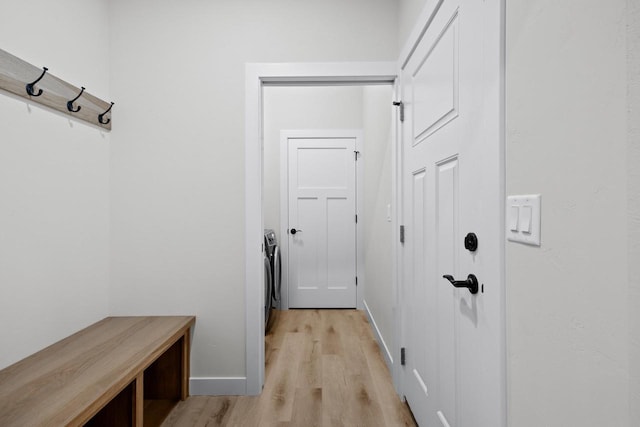 mudroom with washing machine and dryer, light wood-type flooring, and baseboards