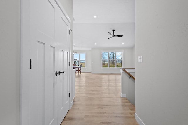 corridor with an upstairs landing, recessed lighting, light wood-type flooring, and baseboards