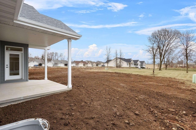 view of yard with a residential view and a patio