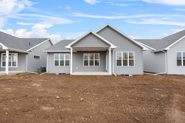 back of property with a patio area and a shingled roof