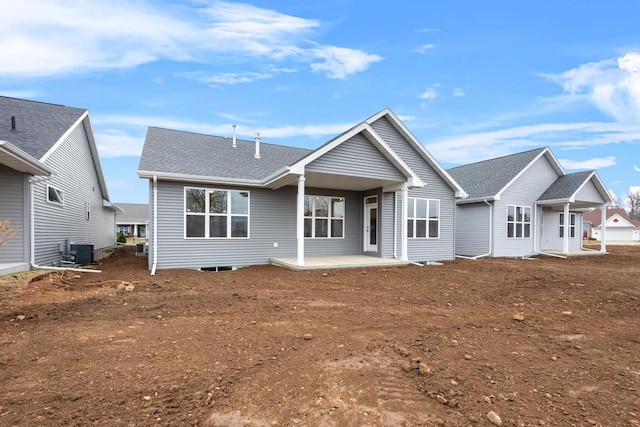 view of front of home with a patio, roof with shingles, and central AC unit