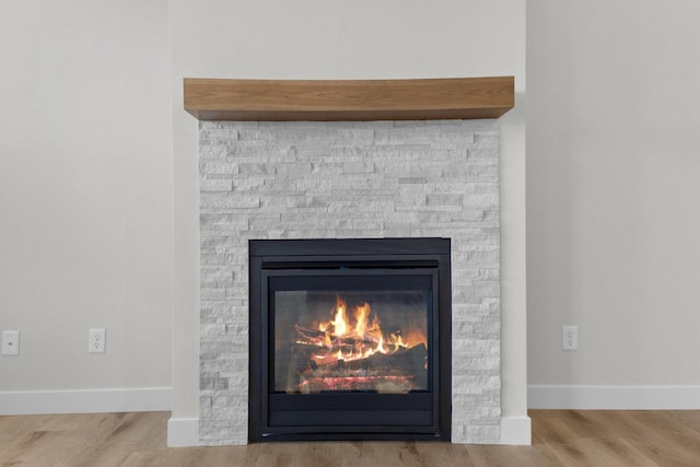 details featuring a fireplace, baseboards, and wood finished floors