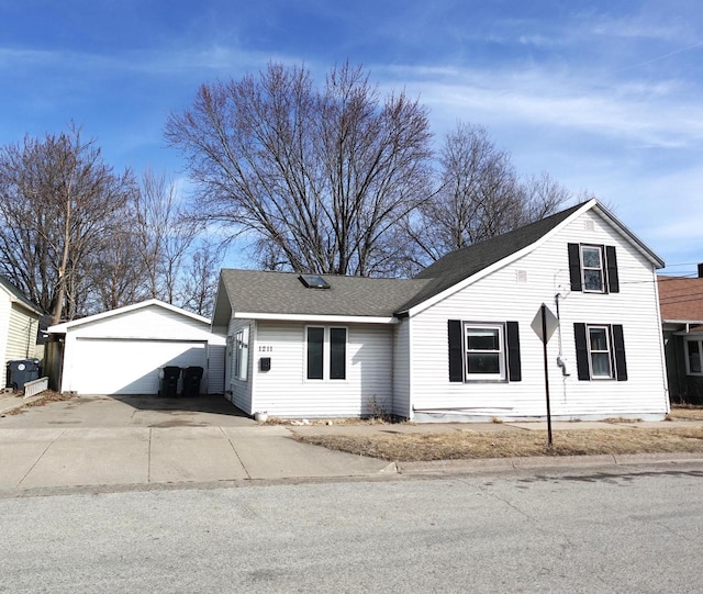 view of front facade with a garage, an outdoor structure, and a shingled roof