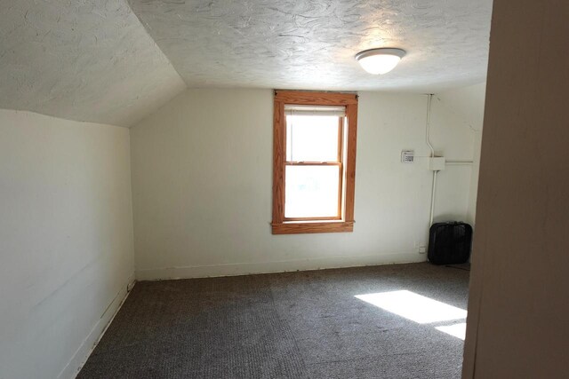 bonus room featuring baseboards, carpet floors, a textured ceiling, and vaulted ceiling