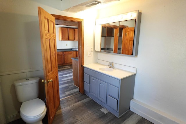 bathroom with visible vents, toilet, vanity, and wood finished floors