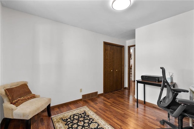 office space featuring wood finished floors, visible vents, and baseboards