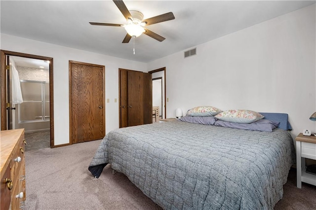 carpeted bedroom with ceiling fan, connected bathroom, visible vents, and multiple closets