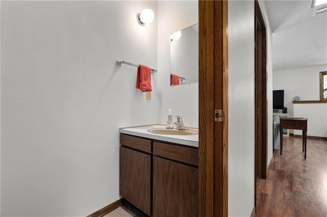 bathroom with vanity, wood finished floors, and baseboards