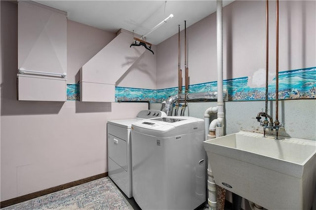 laundry area featuring laundry area, separate washer and dryer, baseboards, and a sink