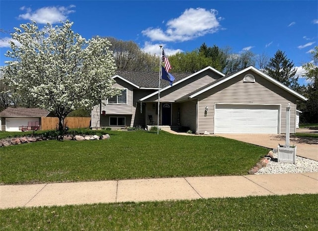 tri-level home with driveway, a front lawn, and a garage