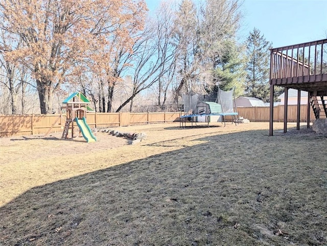 view of play area featuring stairway, a trampoline, a fenced backyard, and a lawn