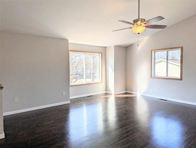 empty room featuring baseboards, dark wood-type flooring, a ceiling fan, and vaulted ceiling