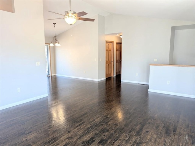 empty room with ceiling fan with notable chandelier, high vaulted ceiling, baseboards, and dark wood-style flooring