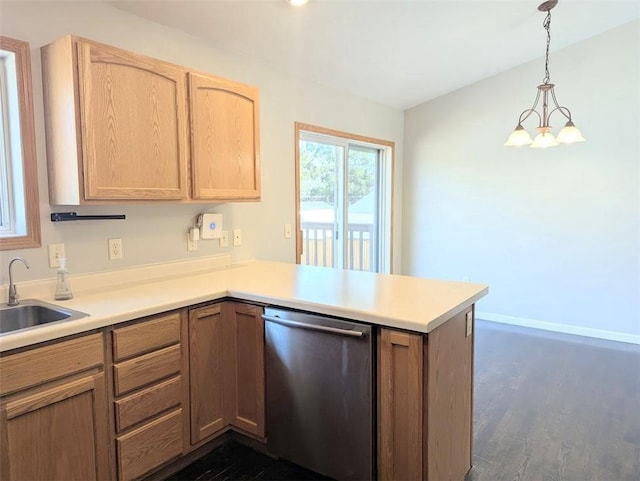 kitchen featuring stainless steel dishwasher, a peninsula, light countertops, and a sink