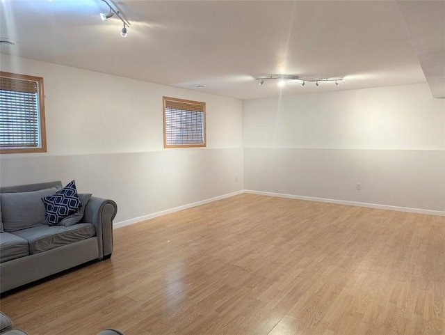 living room featuring track lighting, light wood-style flooring, and baseboards