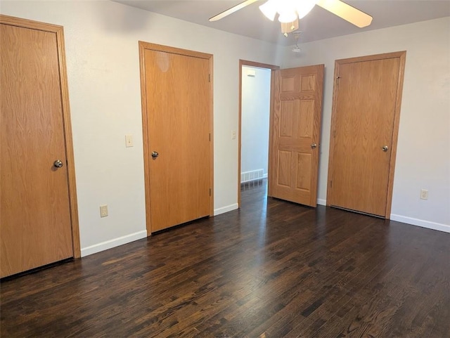 unfurnished bedroom featuring visible vents, baseboards, a ceiling fan, and dark wood-style flooring