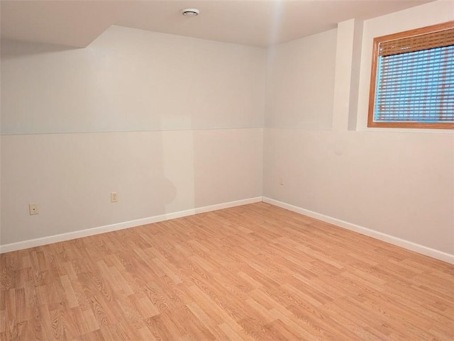 unfurnished room featuring baseboards and light wood-style floors