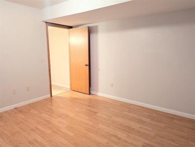 spare room featuring light wood-style flooring and baseboards