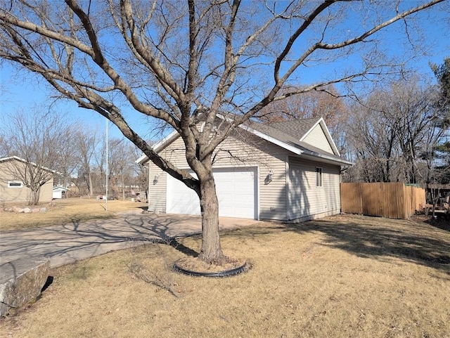 view of side of home with a garage, concrete driveway, and fence