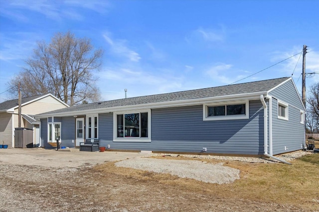 rear view of house with roof with shingles