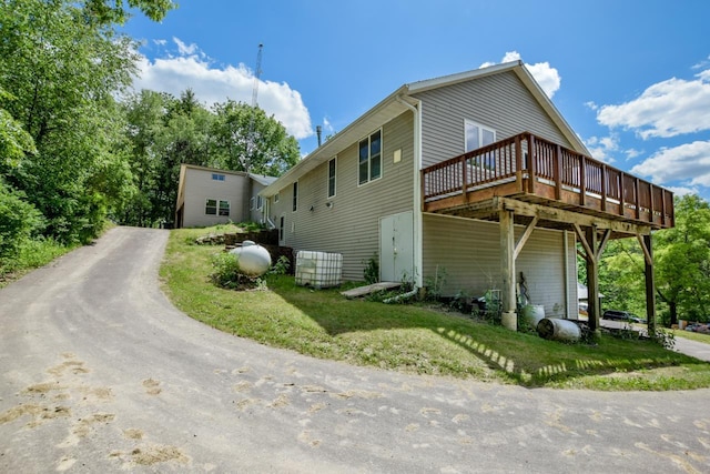 view of property exterior featuring a wooden deck and a yard