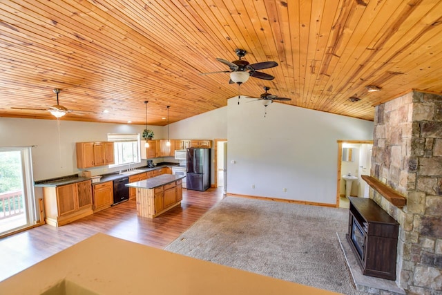 kitchen featuring dark countertops, open floor plan, lofted ceiling, white appliances, and a sink