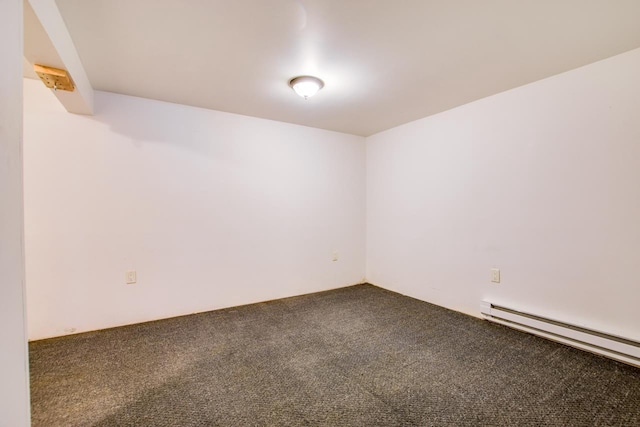 spare room with a baseboard heating unit and carpet