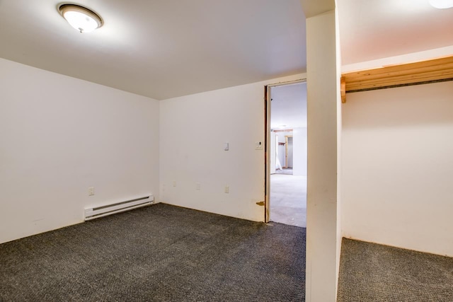 carpeted empty room with a baseboard heating unit