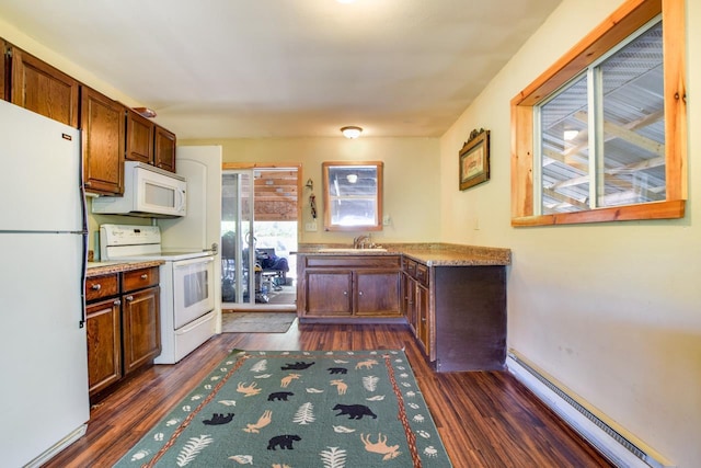 kitchen featuring dark wood finished floors, white appliances, a baseboard heating unit, and a sink