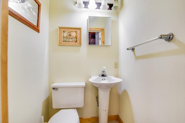 half bath with toilet and a sink