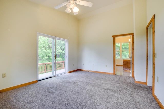 unfurnished room with baseboards, high vaulted ceiling, and carpet