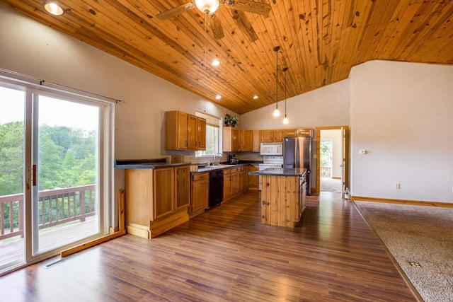 kitchen featuring brown cabinets, a sink, dark countertops, dark wood-style floors, and white appliances