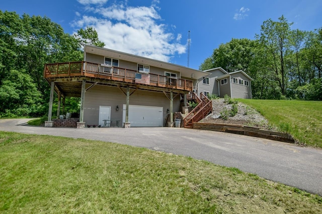 view of front of property with a front lawn, aphalt driveway, a wooden deck, a garage, and stairs