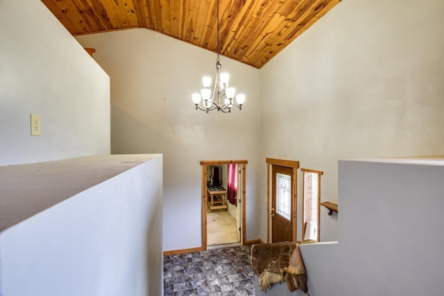 foyer entrance with a notable chandelier, wood ceiling, baseboards, and high vaulted ceiling