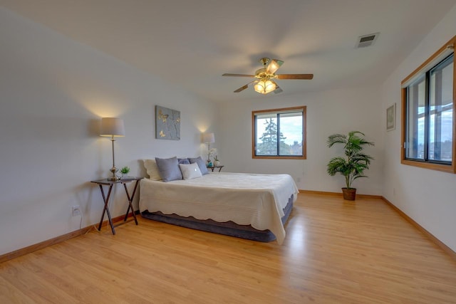 bedroom with visible vents, baseboards, light wood-style floors, and a ceiling fan