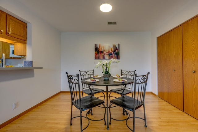 dining room featuring visible vents, light wood-type flooring, and baseboards