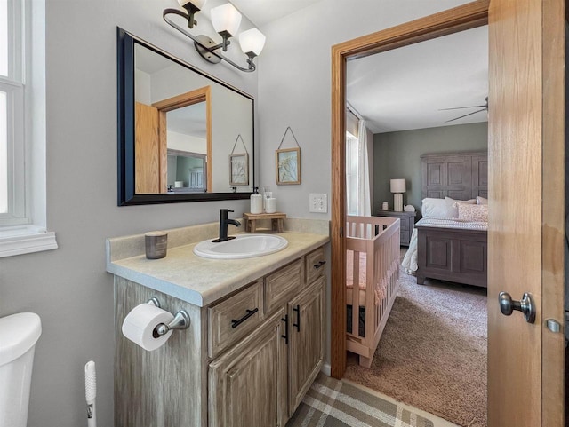 ensuite bathroom featuring vanity, toilet, and connected bathroom