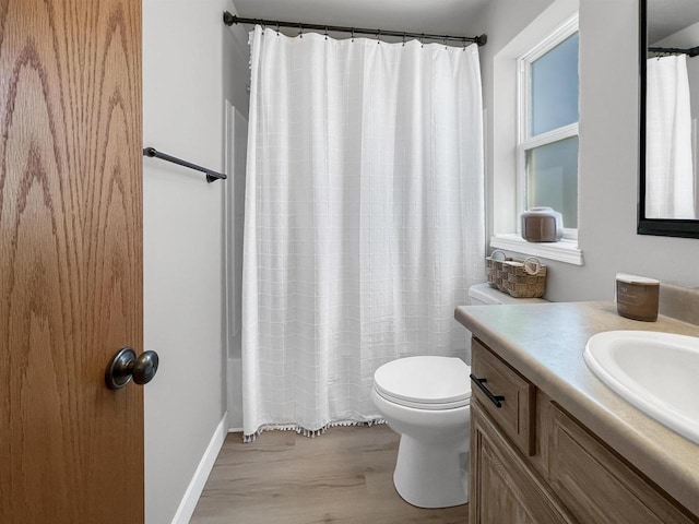 bathroom featuring toilet, vanity, a shower with curtain, and wood finished floors