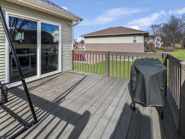 wooden deck with grilling area and a lawn