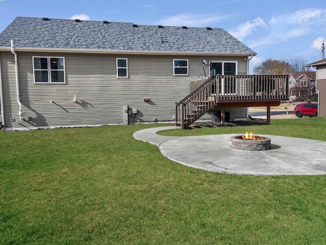 rear view of house featuring an outdoor fire pit, stairs, roof with shingles, a deck, and a yard