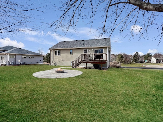 back of property featuring a yard, a patio area, a fire pit, and a deck