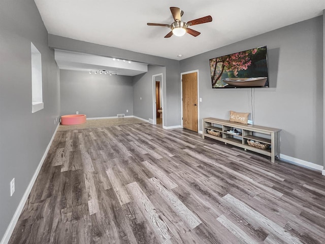 unfurnished living room featuring visible vents, a ceiling fan, baseboards, and wood finished floors