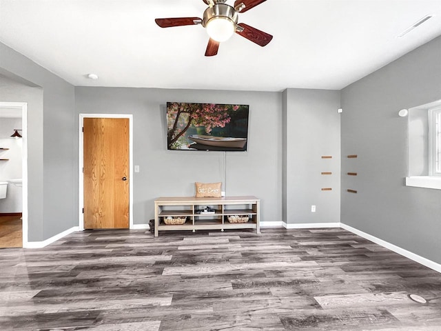 interior space featuring a ceiling fan, visible vents, wood finished floors, and baseboards