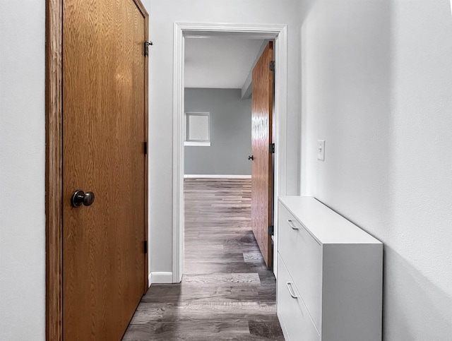 hall with dark wood-type flooring and baseboards