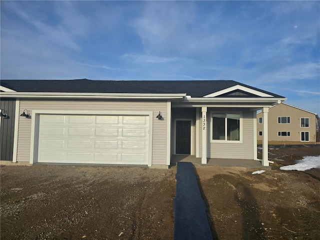 ranch-style house with an attached garage, dirt driveway, and a shingled roof