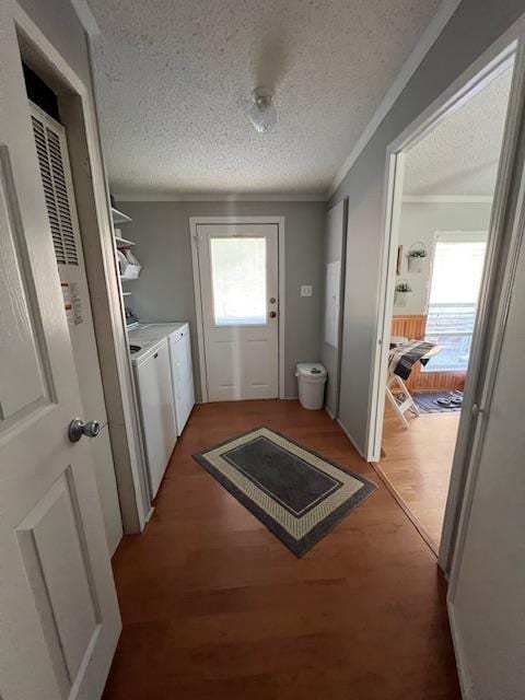 interior space featuring a textured ceiling, light wood-style flooring, crown molding, and washer and clothes dryer