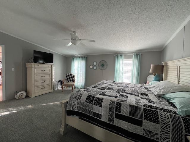 carpeted bedroom with ornamental molding, a textured ceiling, ceiling fan, and vaulted ceiling