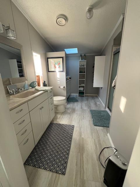 full bath with crown molding, toilet, a stall shower, wood finished floors, and a textured ceiling